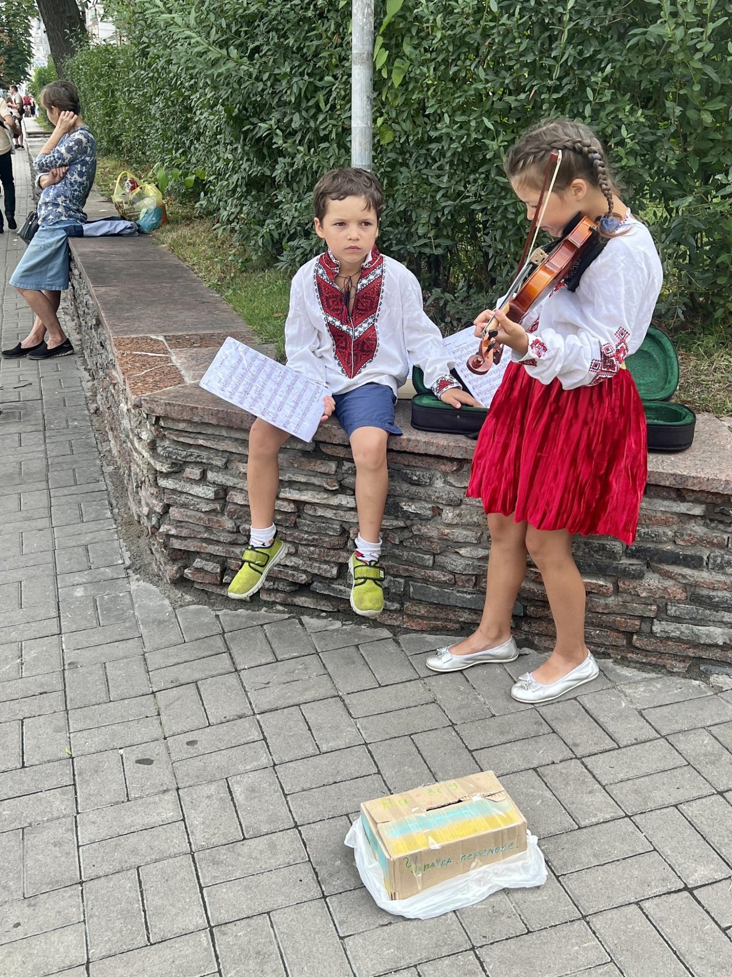 У Києві маленький хлопчик допомагав сестричці, яка грою на скрипці збирала гроші для ЗСУ (фото)